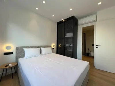 a bedroom with a white bed and a black cabinet at BlueMotion - Cruisenest Transportation included in Piraeus