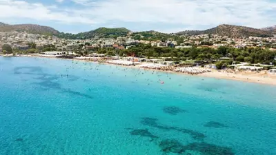 an aerial view of a beach with people in the water at Varkizaki by the sea in Varkiza