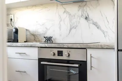a kitchen with white marble counter tops and a stove at Varkizaki by the sea in Varkiza