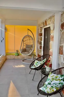 a patio with two chairs and a swing at Beachside Retreat in Glyfada in Athens