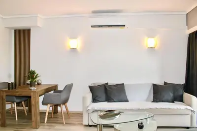 a living room with a white couch and a table at Beachside Retreat in Glyfada in Athens