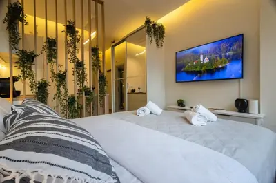 a bedroom with a large white bed with a tv on the wall at Little Paradise in Athens with a Church View in Athens