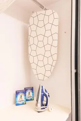 a mirror hanging on a wall above a shelf with books at Little Paradise in Athens with a Church View in Athens