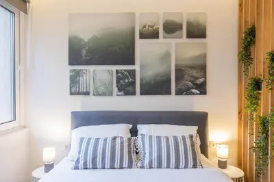 a bedroom with a bed with four pictures on the wall at Little Paradise in Athens with a Church View in Athens