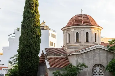 an old church with a tower and a tree at Little Paradise in Athens with a Church View in Athens