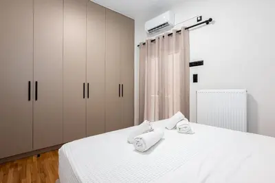 a bedroom with a white bed with towels on it at Stylish 2BR flat near hospital & Panormou metro in Athens