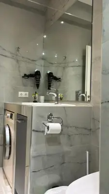 a bathroom with a sink and a toilet and a mirror at Agios Nikolaos apartment in Athens