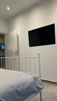 a bedroom with a flat screen tv on the wall at Agios Nikolaos apartment in Athens