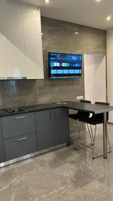 a kitchen with a table and a tv on a wall at Agios Nikolaos apartment in Athens