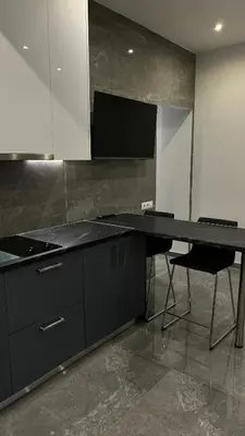 a kitchen with a black counter and a table and chairs at Agios Nikolaos apartment in Athens