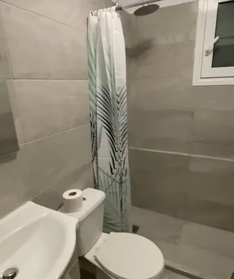 a white bathroom with a toilet and a shower at studio room with private bathroom-floor 2 in Athens