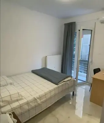 a bed in a white room with a window at studio room with private bathroom-floor 2 in Athens