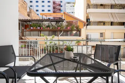a black table and chairs on a balcony at Spacious Luxury Apartment Near Piraeus Port in Piraeus
