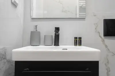 a white sink in a bathroom with a mirror at Spacious Luxury Apartment Near Piraeus Port in Piraeus