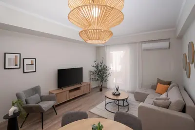 a living room with a couch and a tv at Spacious Luxury Apartment Near Piraeus Port in Piraeus