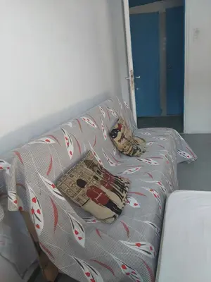 a couch with a blanket and two pillows on it at SHARING ROOM IN NEAR THISSIO METRO STATION BY ACROPOLIs in Athens