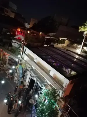 a group of people standing around a food truck at night at SHARING ROOM IN NEAR THISSIO METRO STATION BY ACROPOLIs in Athens