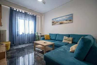 a living room with a blue couch and a table at Athens Vibe Apartment - Gazi by ΜΡS in Athens