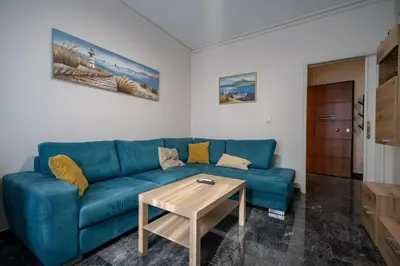 a living room with a blue couch and a table at Athens Vibe Apartment - Gazi by ΜΡS in Athens