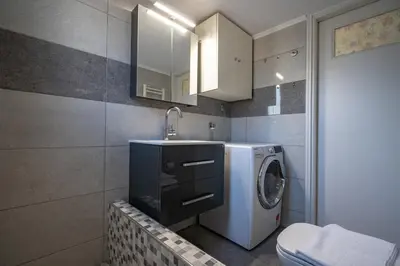 a bathroom with a washing machine and a sink at Athens Vibe Apartment - Gazi by ΜΡS in Athens