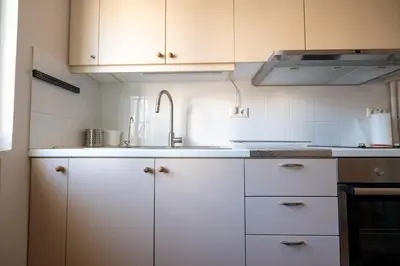 a kitchen with white cabinets and a sink at Athens Vibe Apartment - Gazi by ΜΡS in Athens