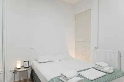 a white bedroom with a bed with towels on it at Aether Athens Luxurious Fully Renovated Apt in Athens