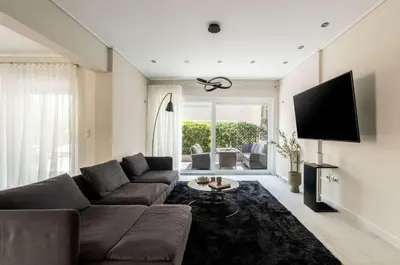 a living room with a couch and a flat screen tv at Elegant 3BD Seaside Villa With Sea View In Vari in Vari