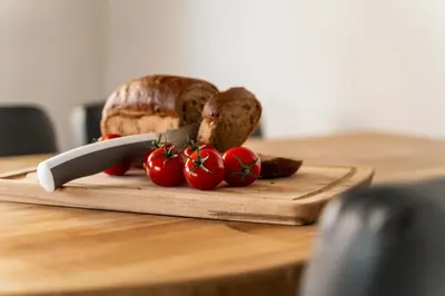 a cutting board with bread and tomatoes on a table at Elegant 3BD Seaside Villa With Sea View In Vari in Vari