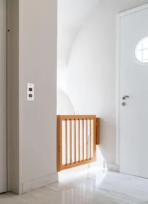 a hallway with white walls and a wooden door at Elegant 3BD Seaside Villa With Sea View In Vari in Vari