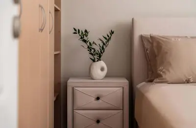 a table with a vase on top of it next to a bed at Elegant 3BD Seaside Villa With Sea View In Vari in Vari
