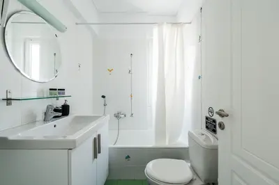 a white bathroom with a sink and a toilet at Elegant 3BD Seaside Villa With Sea View In Vari in Vari