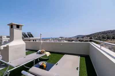 a balcony with a picnic table on the roof at Elegant 3BD Seaside Villa With Sea View In Vari in Vari