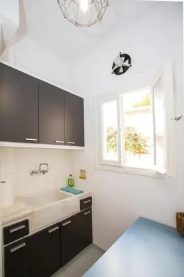 a kitchen with black cabinets and a window at Athens Central Jacuzzi Retreat in Athens