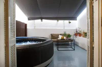 a large tub in a room with a couch at Athens Central Jacuzzi Retreat in Athens