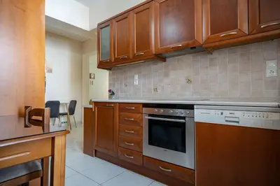 a kitchen with wooden cabinets and a stove top oven at Urban Nest In Chalandri by MΡS in Athens