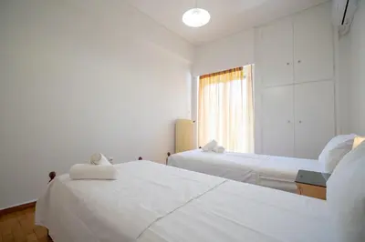 two beds in a room with a window at Urban Nest In Chalandri by MΡS in Athens