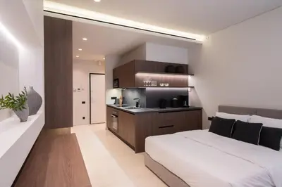 a bedroom with a large bed and a kitchen at Kolonaki Luxury Studios in Athens