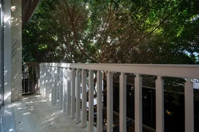a porch with a white railing and a tree at Kolonaki Luxury Studios in Athens