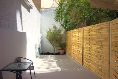 a patio with a wooden fence and a chair at Secret Garden by Acropolis - Athens Central Gem in Athens
