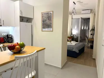 a kitchen and living room with a bowl of fruit on a table at Secret Garden by Acropolis - Athens Central Gem in Athens