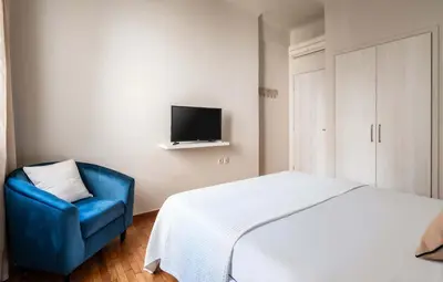 a bedroom with a bed and a blue chair at Relax & Comfy 2BR Apt Close To Athens Center in Athens