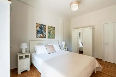 a white bedroom with a white bed and two lamps at Relax & Comfy 2BR Apt Close To Athens Center in Athens
