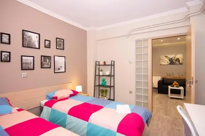 a bedroom with two beds and a living room at 2 bedroom apartment few steps from Plaka in Athens