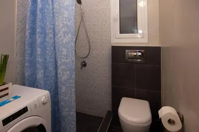 a small bathroom with a toilet and a shower at 2 bedroom apartment few steps from Plaka in Athens
