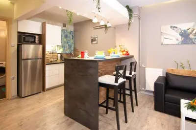 a kitchen with a bar with chairs and a counter top at 2 bedroom apartment few steps from Plaka in Athens