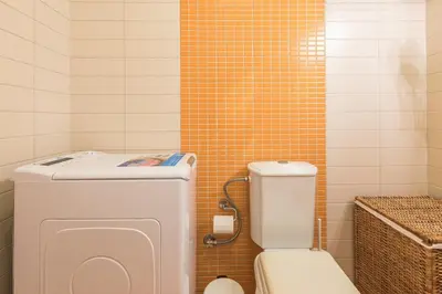 a bathroom with a toilet and a tiled wall at Cozy Athens 2bdr Apartment in Athens
