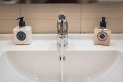 a bathroom sink with two soap bottles on it at Cozy Athens 2bdr Apartment in Athens