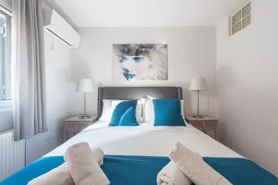 a bedroom with a large bed with blue pillows at Cozy Athens 2bdr Apartment in Athens