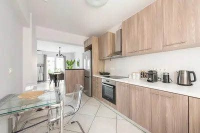 a kitchen with a glass table and wooden cabinets at Cozy Athens 2bdr Apartment in Athens