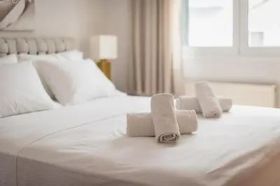 a white bed with three rolled towels on it at Cozy Athens 2bdr Apartment in Athens